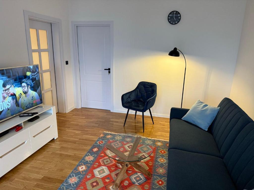 a living room with a couch and a television at Luxury Prishtina Apartment in Pristina