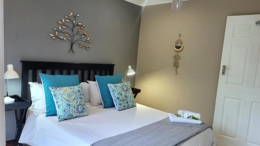 a bedroom with a bed with blue and white pillows at Suite 10- Deja' Blu Bed and Breakfast- East London in East London