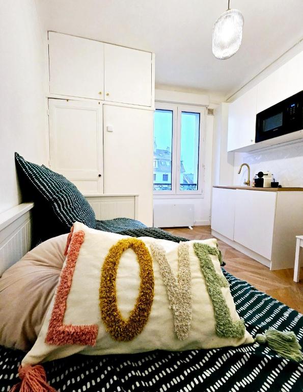 un oreiller avec le mot amour sur un lit dans l'établissement Studio Cœur de Deauville à 10 minutes à pied de la plage, à Deauville
