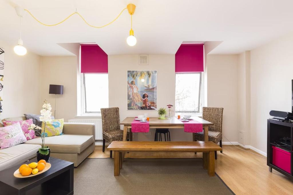 una sala de estar con un sofá y una mesa en Trendy Spacious 1 Bedroom Flat, en Londres