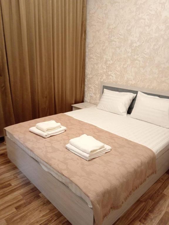 a bed with two towels on top of it at Hotel Murodjon in Samarkand