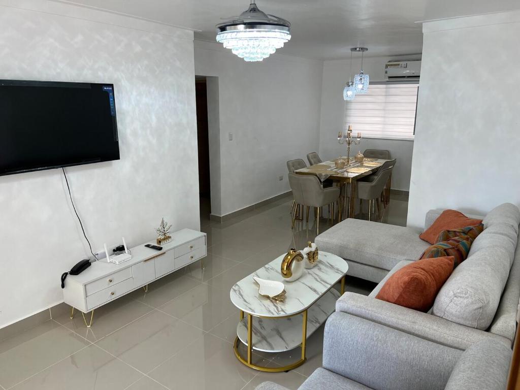 a living room with a couch and a flat screen tv at Olympus Paradise in Juan López