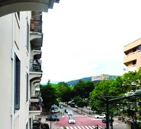 une rue de la ville avec des voitures garées dans un parking dans l'établissement Appartement familial hyper bien situé, à Annecy