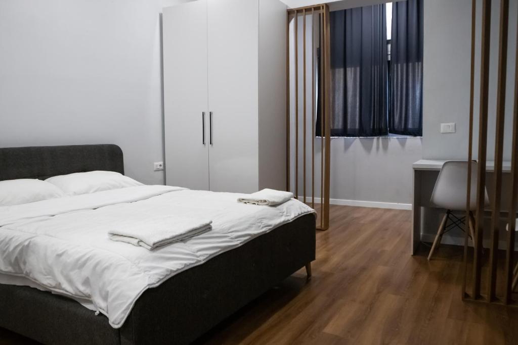 a bedroom with a bed and a table and a chair at Be Solei Studio Apartments Sol 1 in Tirana