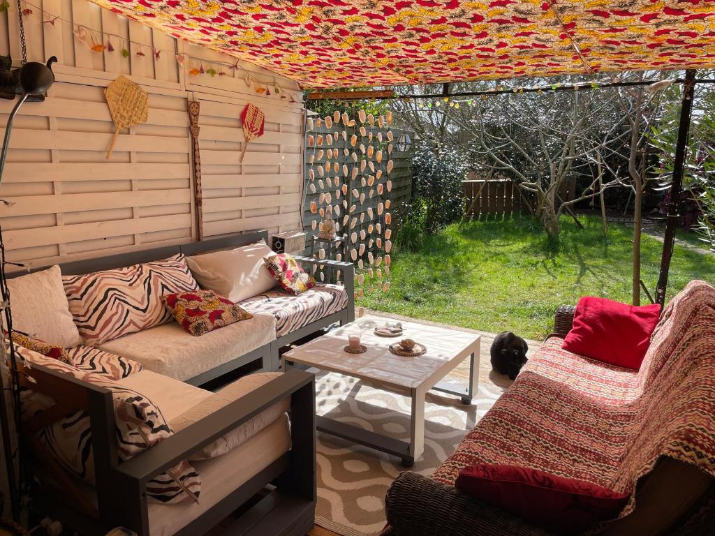 une véranda avec un canapé et une table dans l'établissement La Chambre Du Voyageur, à Soustons