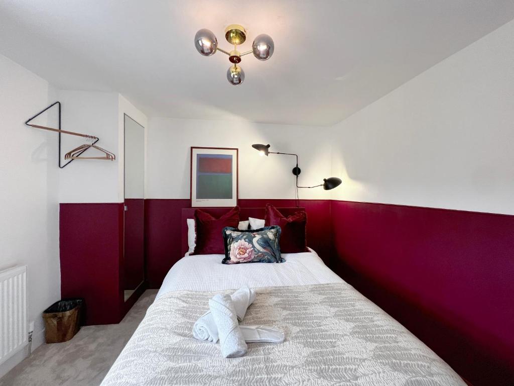 レディングにあるBoutique Double Room in Terrace Home - University Hospital City Centreの赤と白の壁のベッドルーム1室、ベッド1台が備わります。