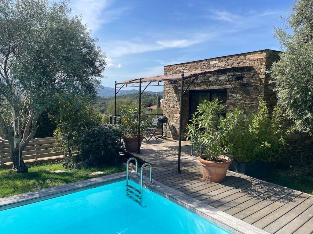 a swimming pool in front of a stone house at A Casetta Di Oletta in Oletta