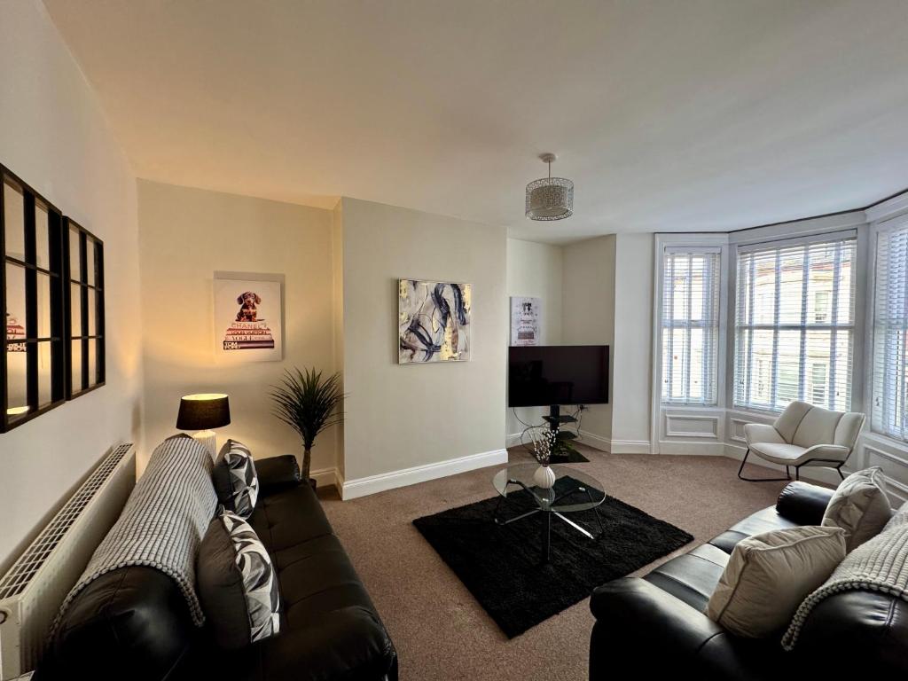 a living room with a couch and a tv at Ocean Apartment, Spacious 5 bedroom holiday home in Whitley Bay