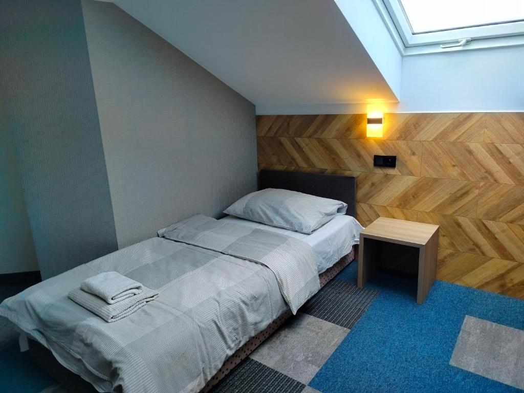 a small bedroom with a bed and a table at Hotelik Krakowiak in Jarosław