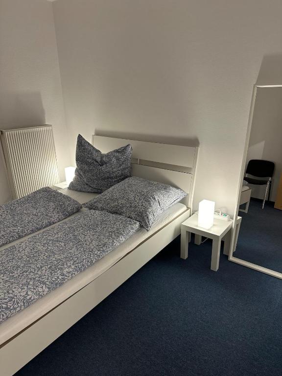 a bedroom with a bed with two pillows and a table at Sonnenlage - Ferienwohnung nahe Pforzheim-Karlsruhe - 7 Minuten zur A8 in Eisingen