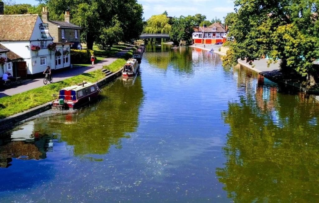 a river with boats in the middle of a town at Central with River Views in Chesterton