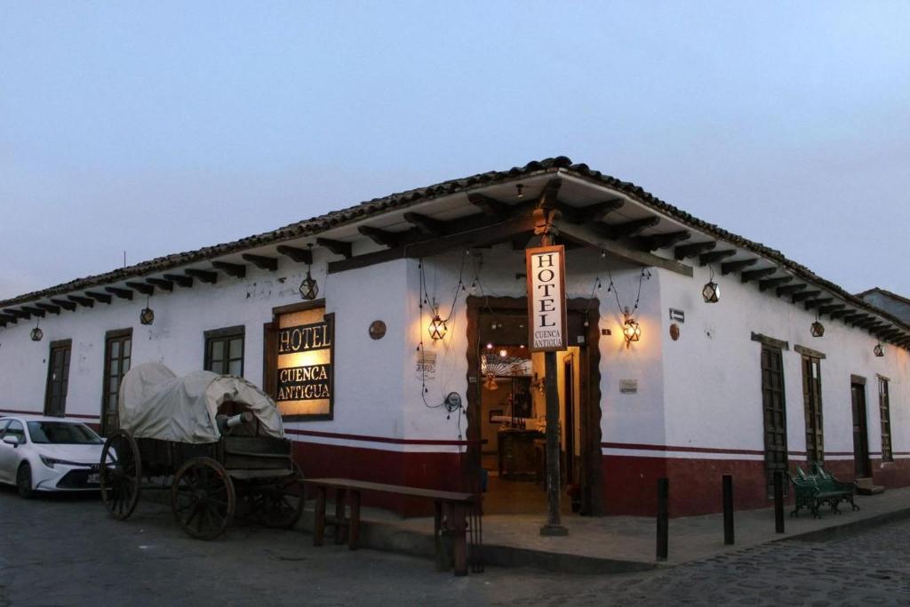 a white building with a car parked in front of it at Hotel y restaurante Cuenca Antigua in Mazamitla