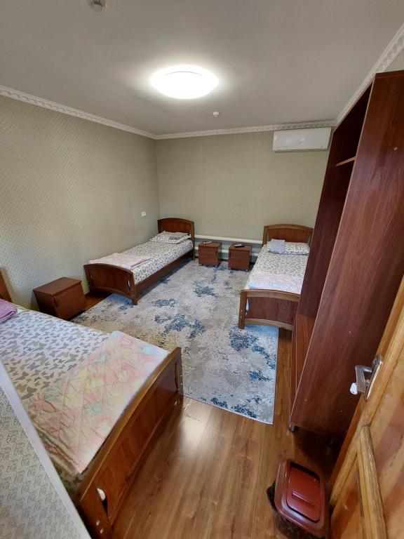 una habitación con tres camas en una habitación en Hostel Room, en Tashkent