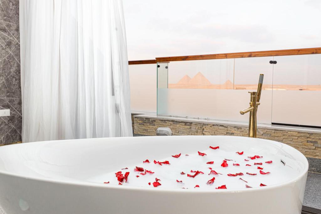 a bathroom with a bath tub filled with red butterflies at Sultan Pyramids Boutique Hotel View in ‘Ezbet `Abd el-Ḥamîd