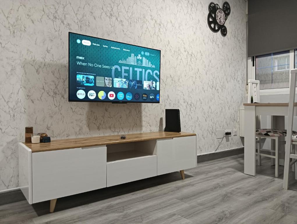 a living room with a tv on a wall at Apartamento Exterior Camino Inglés # a 10 min de Santiago in Sigüeiro