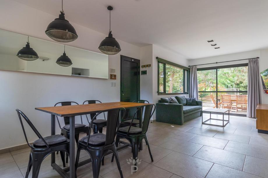 a kitchen and living room with a table and chairs at PRANAMAR, apart del bosque in Santa Teresita