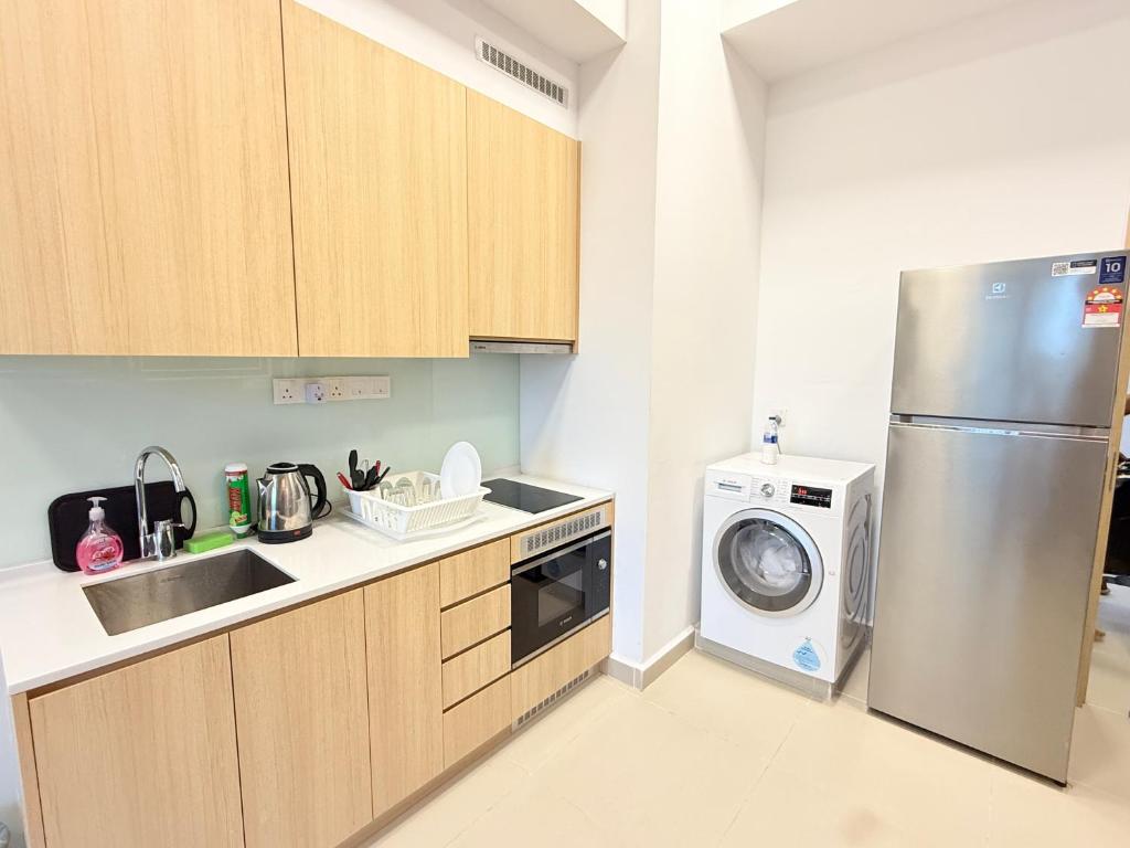 a kitchen with a refrigerator and a washing machine at Colony Service Suites Kuala Lumpur in Kuala Lumpur