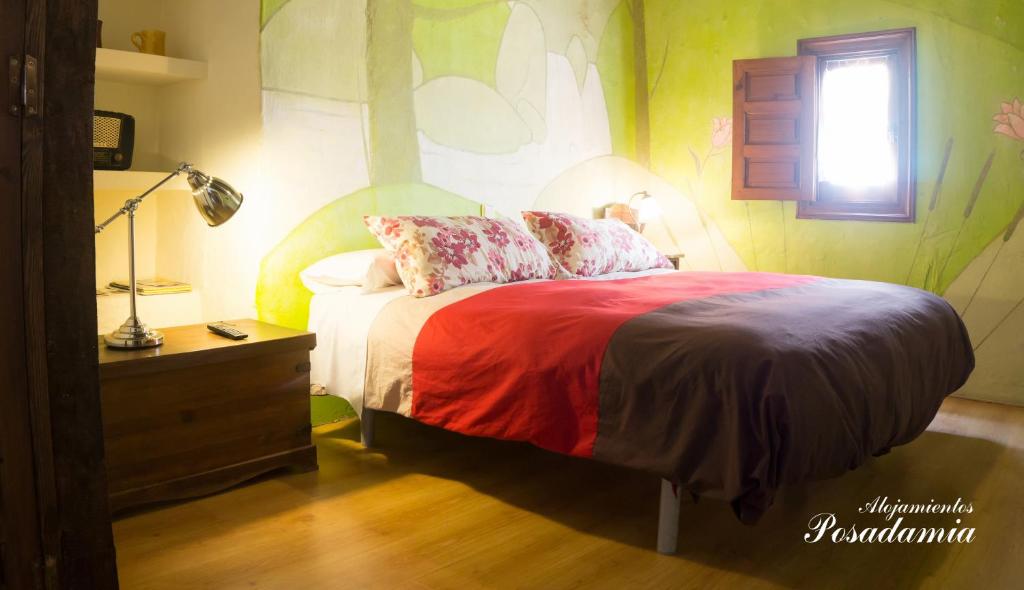 a bedroom with a bed and a lamp and a window at Posada El Canchal in Arenas de San Pedro