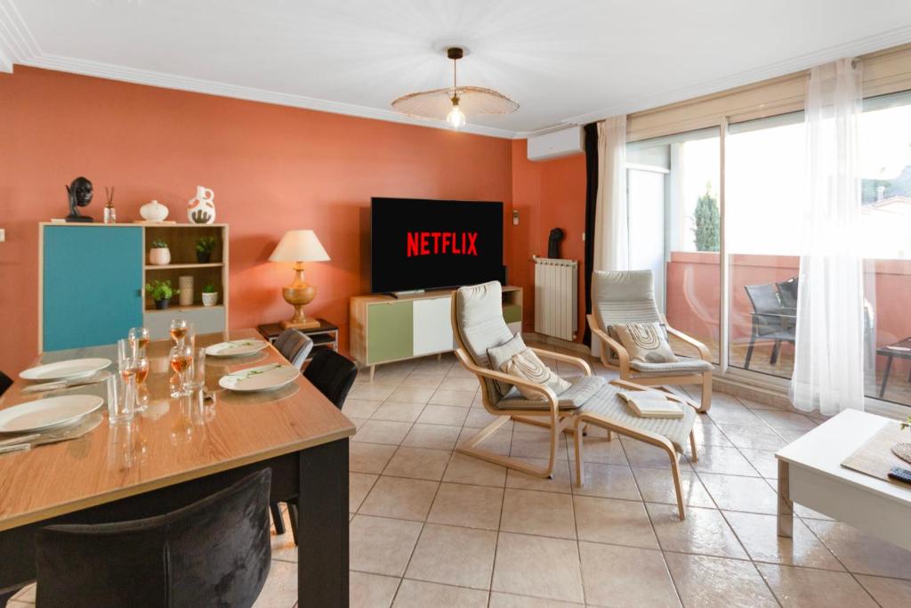- un salon avec des murs orange, une table et des chaises dans l'établissement Le Nala - Spacious - AC - WIFI - 10 min from the sea, à Nice
