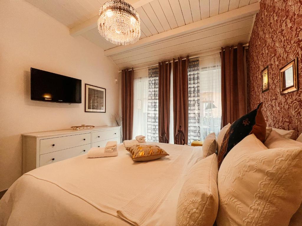 ein Schlafzimmer mit einem großen weißen Bett und einem Kronleuchter in der Unterkunft Casa Riad,gioiello del cortiletto storico in Lesmo