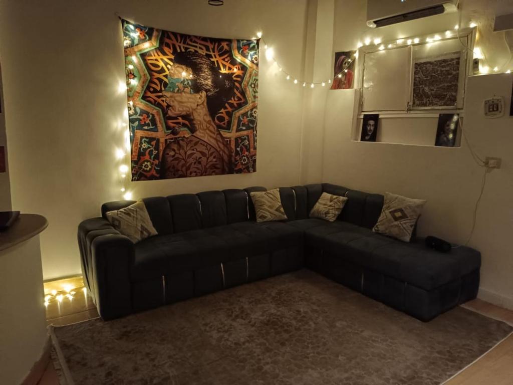 a living room with a black couch and a painting at LUKA House in Dahab