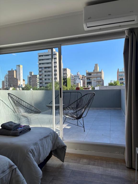 um quarto com uma cama e uma varanda com vista em Av Suites em Rosário