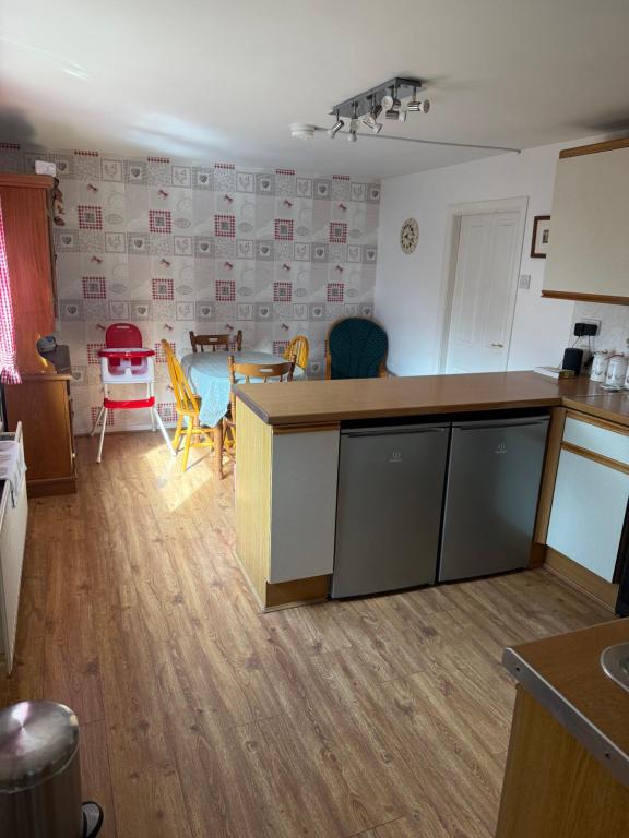 une cuisine et un salon avec une table et des chaises dans l'établissement Laurel Country Cottage, à Ballymena