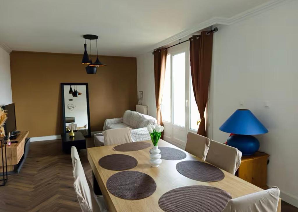 une salle à manger avec une table et un canapé dans l'établissement Bel appartement proche gare et centre ville, au Mans