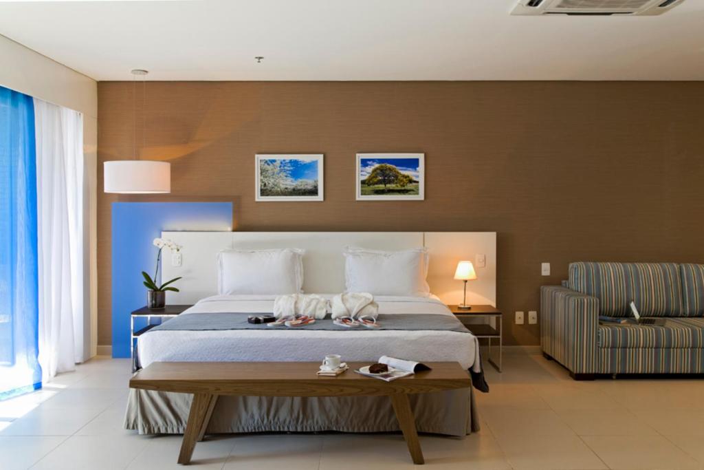 a bedroom with a bed with two dogs on it at Intercity Salvador in Salvador