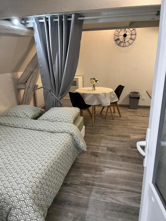 une chambre avec un lit et une table avec des chaises dans l'établissement Modern and bright studio, à Bourges