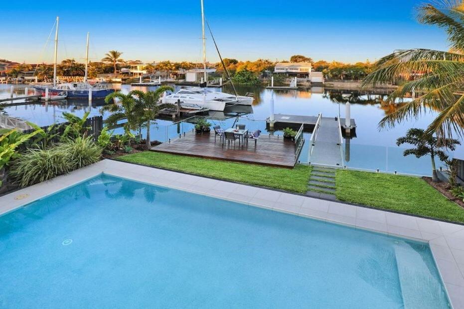 a large swimming pool in front of a marina at WATERFRONT HOME BORDERING MOOLOOLABA in Buddina