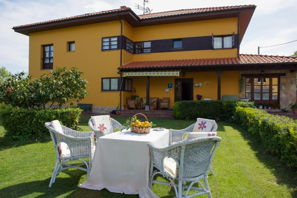 a table and chairs in front of a yellow house at Hotel Camangu in Camango