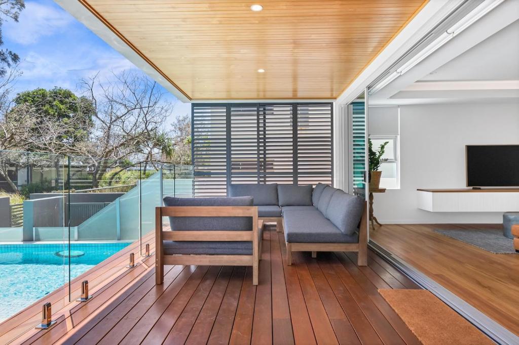 a living room with a table and chairs and a pool at BEACH01- Mooloolaba Beachfront Apartment with Private Pool in Mooloolaba