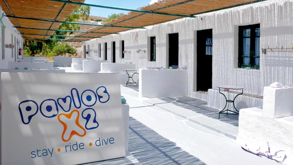 a white building with a sign that reads pandosstaystayillinillinide at Pavlosx2 in Chora Folegandros