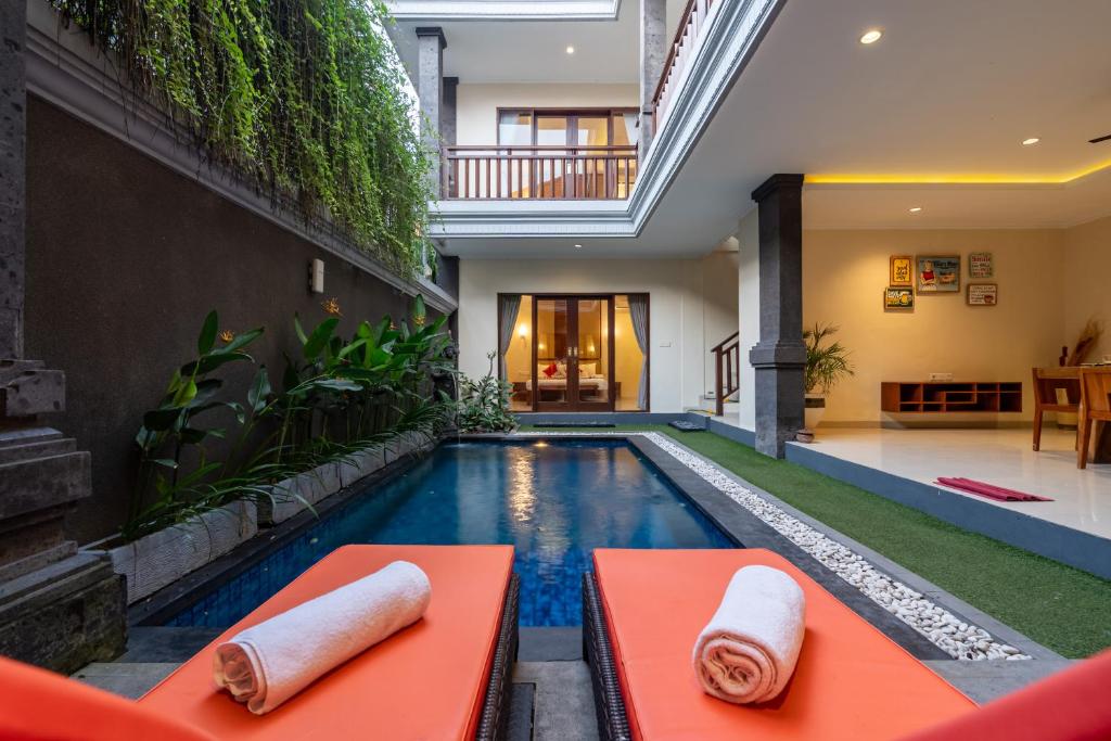 an indoor pool in a house with an orange bench at De' Bharata Bali Villas in Seminyak