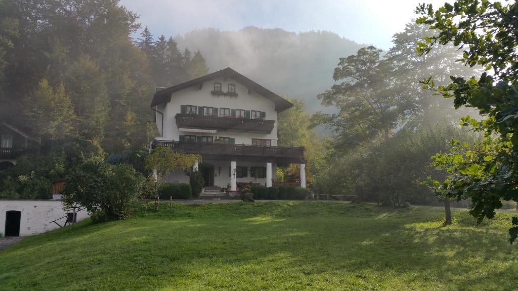 una casa in cima a una collina con un cortile verde di Villa Bergkristall a Eschenlohe