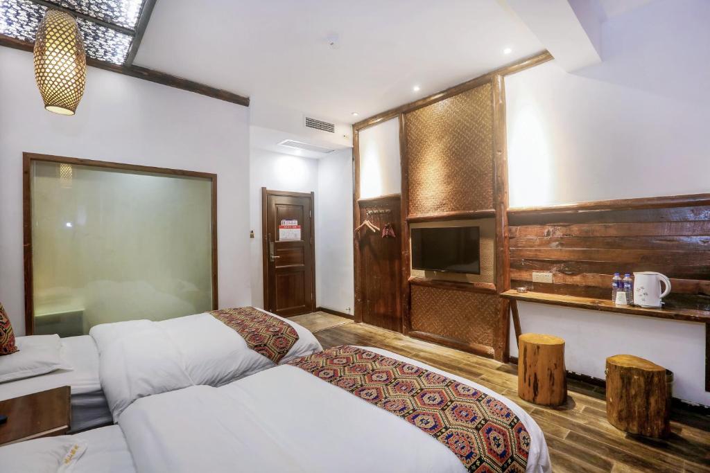 a hotel room with two beds and a tv at 张家界畔山驿栈 in Zhangjiajie