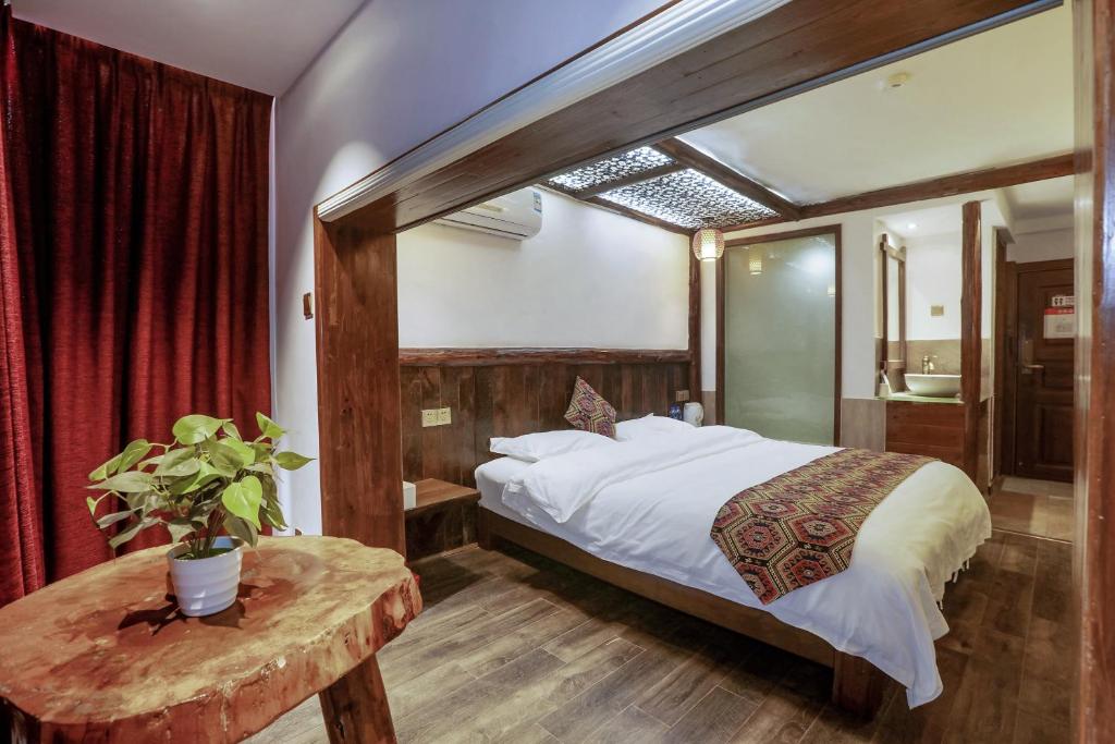 a bedroom with a bed and a table and a mirror at 张家界畔山驿栈 in Zhangjiajie