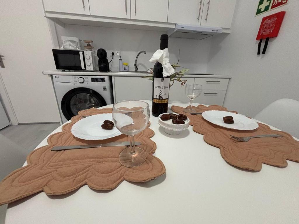 a table with two plates and a bottle of wine at Casa da Praça I in Vila Nova