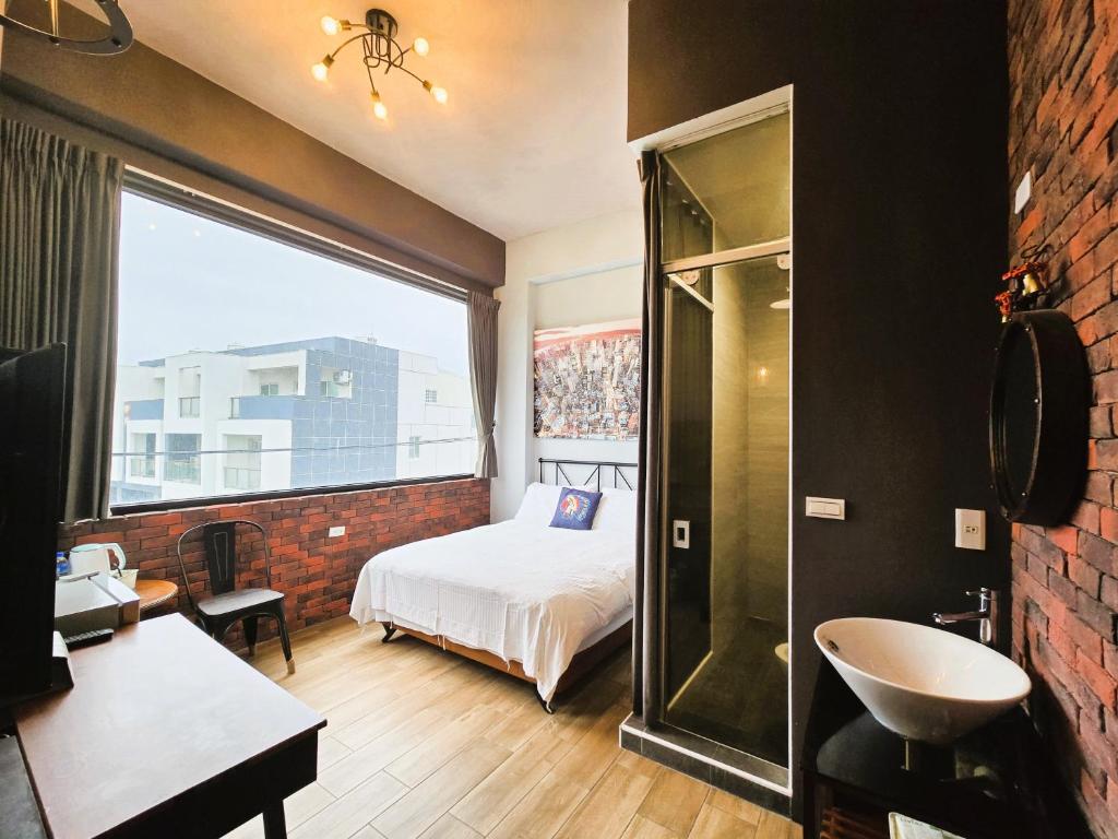 una camera con letto, lavandino e finestra di Lancasa Taitung a Città di Taitung