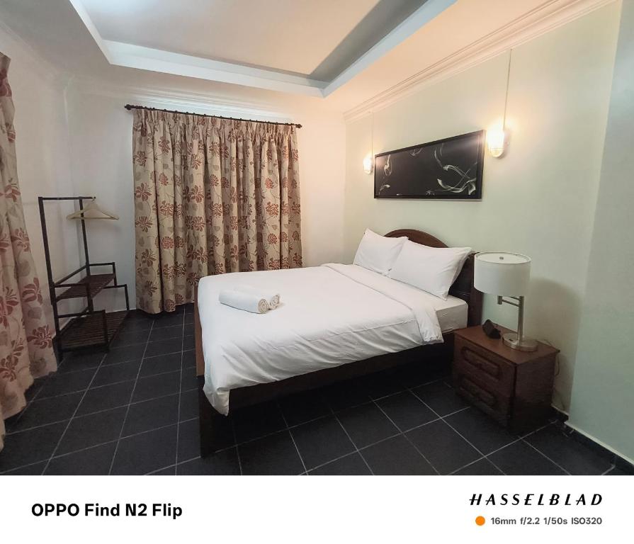 a hotel room with a bed and a window at FZ Tuaran Country Village in Tuaran