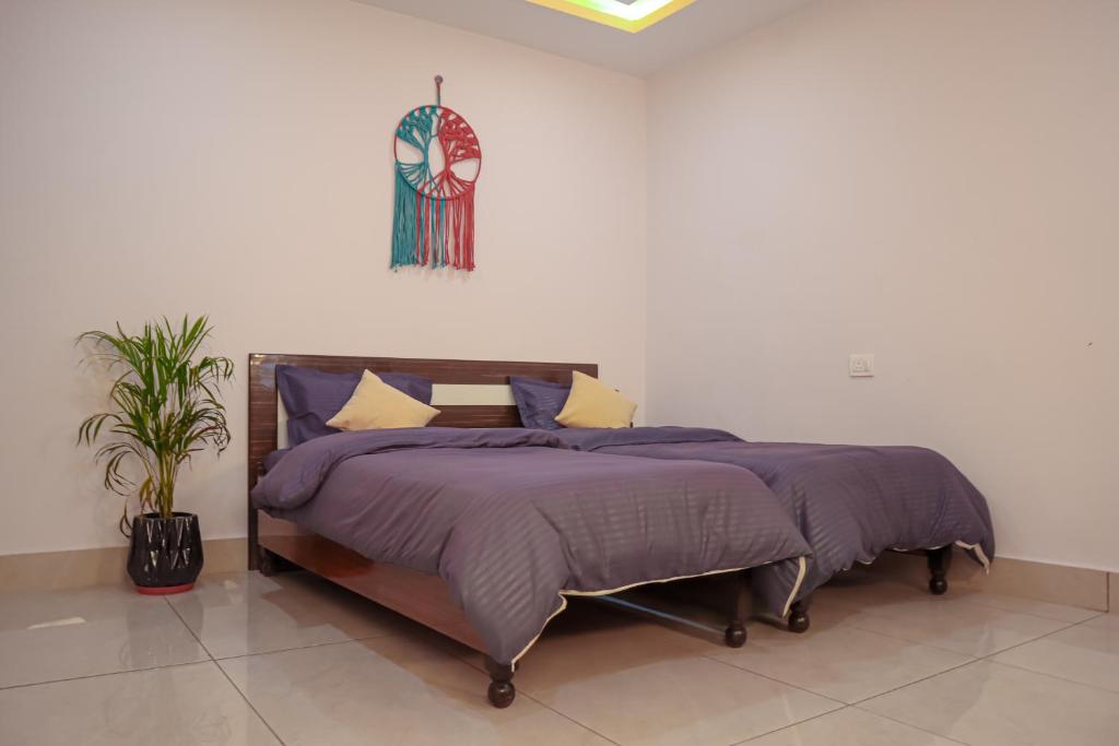 a bedroom with a bed with purple sheets and a potted plant at Blissful stays midst nature in Rishīkesh