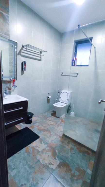 a bathroom with a toilet and a sink and a mirror at Serene Hills Home in Nairobi