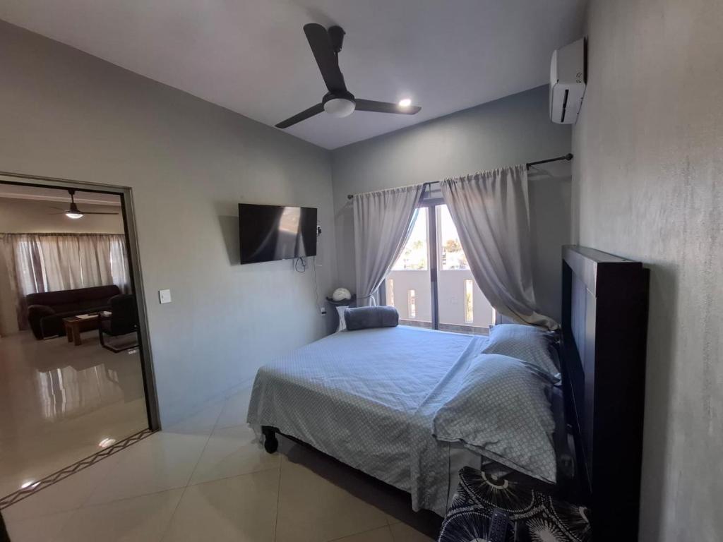 Schlafzimmer mit einem Bett, einem Deckenventilator und einem Fenster in der Unterkunft Departamentos La Roca D7 in La Peñita de Jaltemba