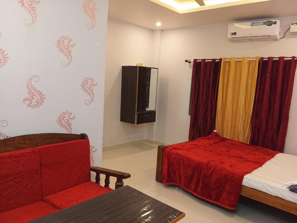 a room with a bed and a couch and a chair at Rooms & Food Sri Ranga in Belūr