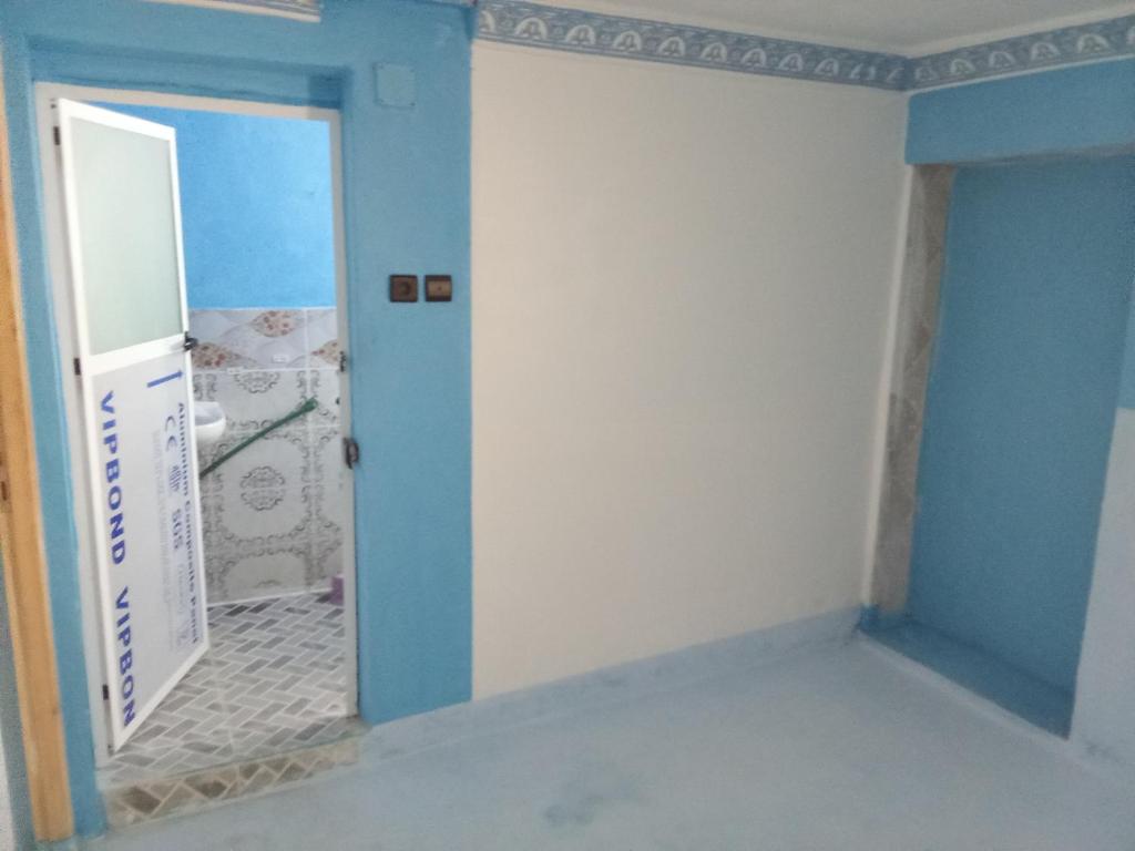 una stanza con una parete blu e bianca e una porta di Dar zitouna a Chefchaouen