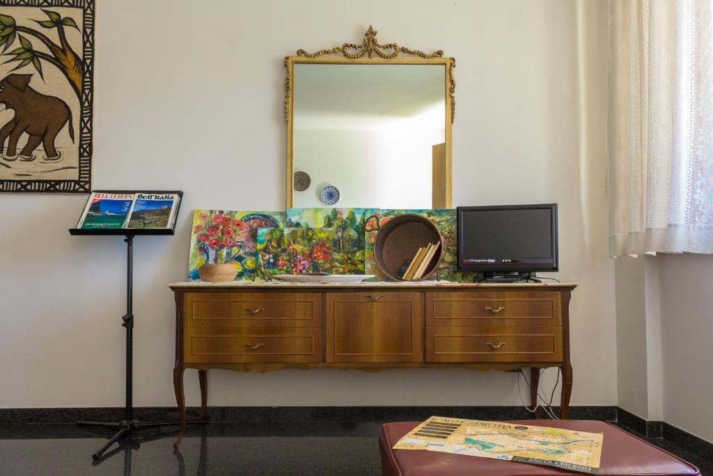 a bathroom with a dresser with a mirror and a television at Le Monachette in Ascoli Piceno