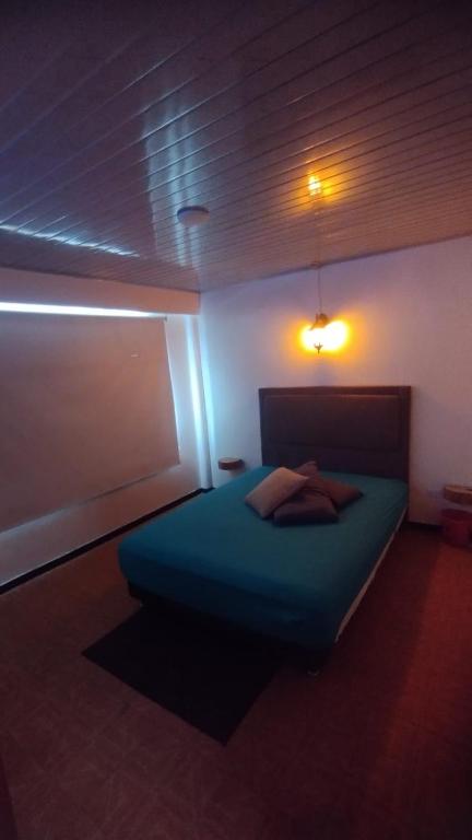 a bedroom with a blue bed in a room at Centro histórico de CHIA habitaciones baño compartido parqueadero in Chía