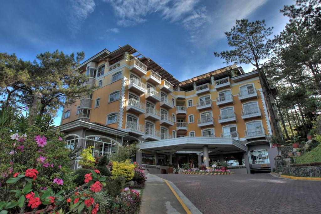 a large building with flowers in front of it at Hotel Elizabeth - Baguio in Baguio