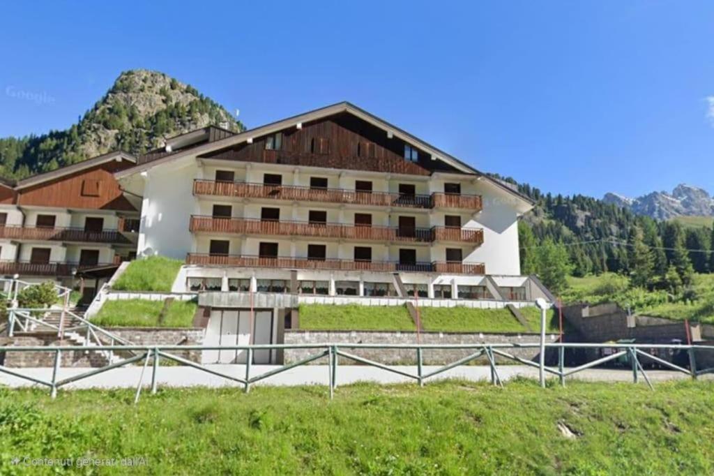 un grande edificio in mezzo a un campo di Casina Alpina sugli impianti Passo S Pellegrino a Passo San Pellegrino